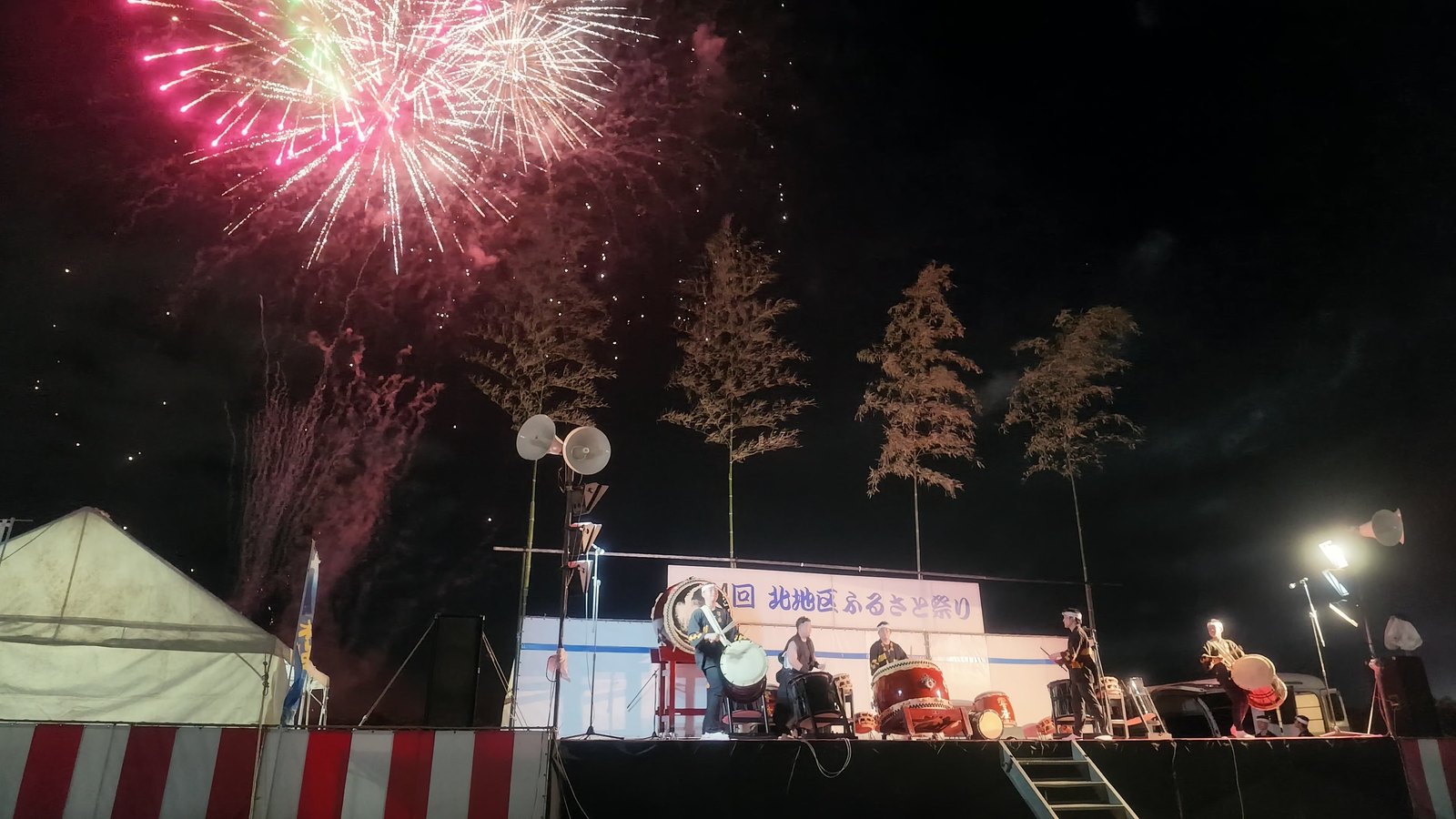 夜空に広がる花火と、竹飾りのステージ